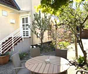 a wooden table and chairs in front of a house at Ferienwohnung Seeblick Ratzeburg in Ratzeburg