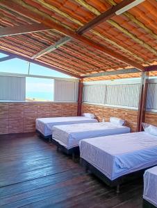 a large room with three beds in it at Casa do Seu Lourenço in Beberibe
