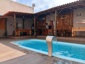 a swimming pool with a water fountain in a house at Casacapuba Jacaraipe Es in Serra