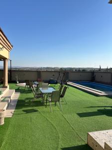 a patio with green grass and a table and chairs at Piink Lopez in Manzini