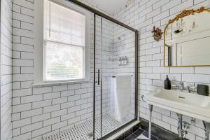 a white tiled bathroom with a shower and a sink at 2-Unit Bundle in Eustis: Walk to Ferran Park! in Eustis +36 photos