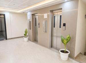 a hallway with two potted plants in a building at Hotel Sanidhyam Bliss in Varanasi +50 photos