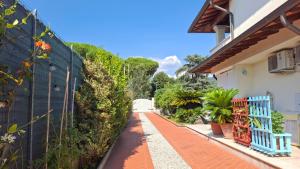 a pathway next to a house with a blue fence at Villa Incanto in Forte dei Marmi
