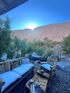 two benches with pillows on them in the desert at Alcohuaz Indomito in Alcoguaz