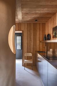 a kitchen with wooden walls and a table and a chair at Herbighe Retreat in Asiago