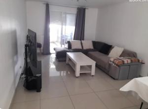 a living room with a couch and a table and a tv at Maison de vacance Montpellier in Montpellier