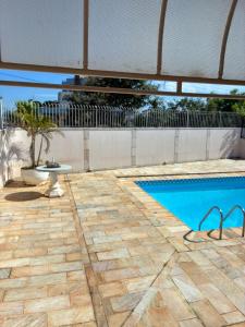 a patio with a swimming pool and a table at Quarto próximo ao Lago do Major in Atibaia +6 photos