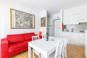 a living room with a red couch and a white table at Piscina Gratis, Pool View Oasis Pool View in Lido Adriano
