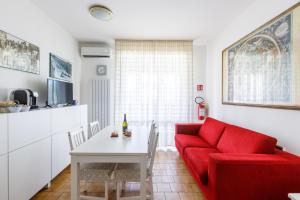 a living room with a red couch and a table at Piscina Gratis, Pool View Oasis Pool View in Lido Adriano