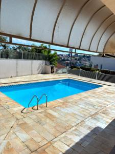 a swimming pool with an awning on a building at Quarto próximo ao Lago do Major in Atibaia