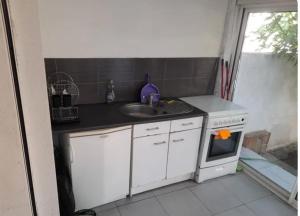 a small kitchen with a sink and a stove at Maison de vacance Montpellier in Montpellier +3 photos