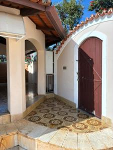 an entry to a house with a red door at Quarto próximo ao Lago do Major in Atibaia