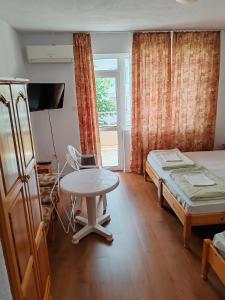 a bedroom with a table and a bed and a table and chair at Zlatevi Guest House in Obzor