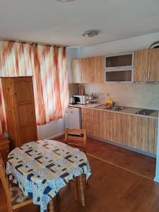 a kitchen with a table and a table and a table and a kitchen at Zlatevi Guest House in Obzor