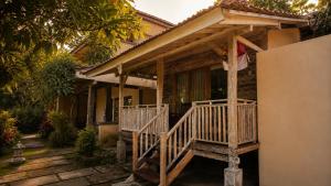 a house with a wooden porch with a porch at Indraprastha 2 Bungalow in Ubud