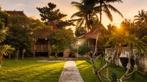 a house with a pathway in front of a yard at Indraprastha 2 Bungalow in Ubud