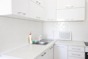 a white kitchen with white cabinets and a sink at Rasi Luxury Apartments in Ulcinj +80 photos