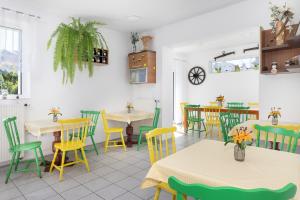 a restaurant with yellow and green chairs and tables at Hołcyna 21 in Brenna