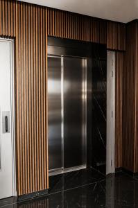 ein Edelstahlkühlschrank in einem Raum mit Holzwänden in der Unterkunft Rois Constructions in Nikosia