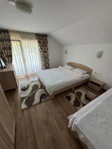 a bedroom with two beds and a rug at Pensiunea Edy in Statjunea Borsa