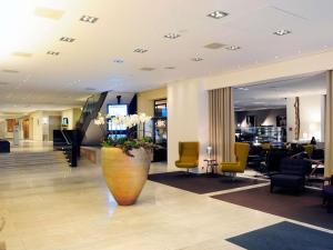 eine Lobby mit einer großen Vase mit Blumen darin in der Unterkunft Pullman Eindhoven Cocagne in Eindhoven