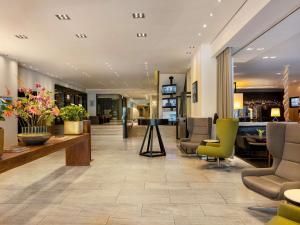Eine Krankenhauslobby mit Stühlen und einem Tisch in der Unterkunft Pullman Eindhoven Cocagne in Eindhoven + 245 Fotos