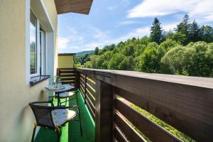 a balcony with a table and chairs on a fence at Hołcyna 21 in Brenna