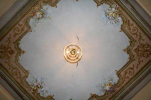 a ceiling with a chandelier and flowers on it at Résidence La Villa Léonie in Nice