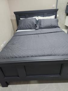 a bed in a bedroom with a black bed frame at K&C RENTALs in Mount Gay