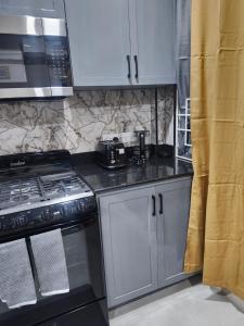 a kitchen with white cabinets and a stove top oven at K&C RENTALs in Mount Gay +3 photos