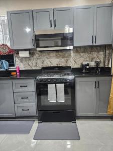 a kitchen with a stove and a microwave at K&C RENTALs in Mount Gay