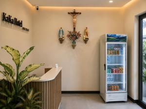 a refrigerator in a room with a cross on the wall at KAKA HOTEl - KDC TÂN ĐỨC in Ðức Hòa