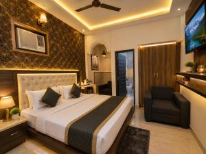 a bedroom with a bed and a chair and a television at Hotel Bell Montana Stay Near IGI Airport Delhi- Free Airport Pickup & Drop in New Delhi
