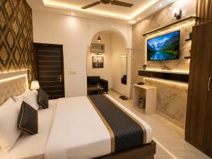 a bedroom with a bed and a tv on a wall at Hotel Bell Montana Stay Near IGI Airport Delhi- Free Airport Pickup & Drop in New Delhi