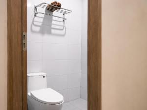 a bathroom with a white toilet and a shelf at KAKA HOTEl - KDC TÂN ĐỨC in Ðức Hòa