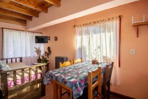 a dining room with a table and a bed at Cabañas Lago Guillelmo in San Carlos de Bariloche