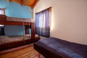 a bedroom with two bunk beds and a window at Cabañas Lago Guillelmo in San Carlos de Bariloche