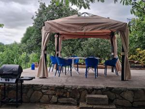 a gazebo with blue chairs and a table at Casa Marza in Ghioroc
