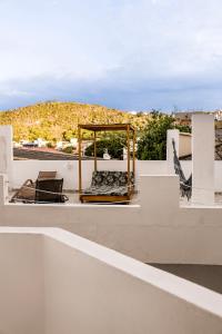 a balcony with a bed and chairs on a roof at Pousada do Trovão - Melhor localização de Arraial in Arraial do Cabo