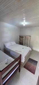 a room with two beds and a bench in it at Pousada Parque dos Coqueiros in Piaçabuçu