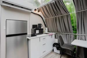 a kitchen with a refrigerator and a table and a chair at Studio Capsule House in Parry Sound #31 in Parry Sound