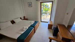 a bedroom with a large bed with a view of a patio at Hotel Pashos in Kriopigi