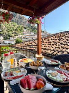 a table with plates of food on a table with a view at MEROLI Guesthouse - UNESCO quarter in Berat +47 photos