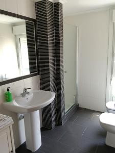 a bathroom with a sink and a toilet and a mirror at Casa Vistas in Santa Marta de Ortigueira