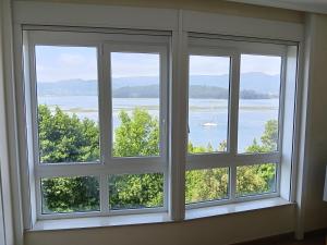 a window with three views of a boat in the water at Casa Vistas in Santa Marta de Ortigueira