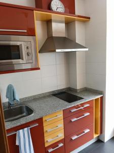 a small kitchen with a sink and a microwave at Casa Vistas in Santa Marta de Ortigueira