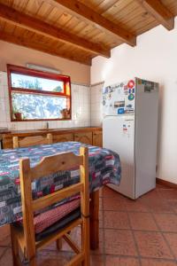 a kitchen with a refrigerator and a table at Cabañas Lago Guillelmo in San Carlos de Bariloche