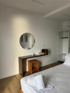 ein Schlafzimmer mit einem Bett und einem Spiegel in der Unterkunft Solemare in Himarë