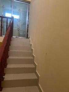 a staircase in a building with a window and a stair case at Hotel Mardoche Banto in Luanda +1 photo