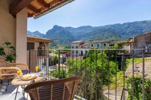 a balcony with a table and chairs and mountains at Can Perla in Sóller